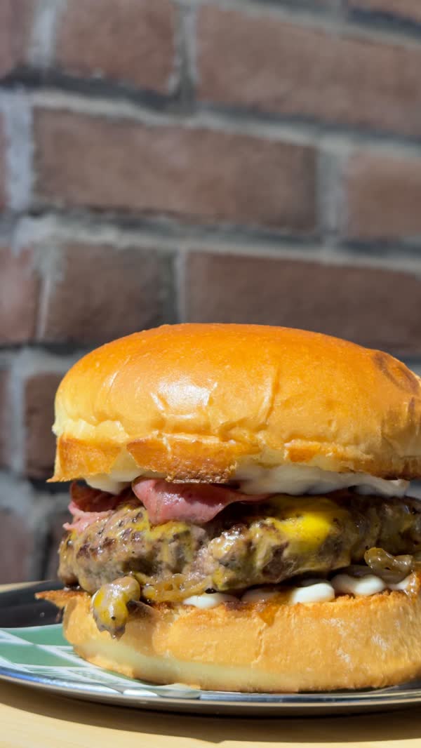 Tuğla duvar önünde pastırmalı burger